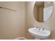 Small powder room with pedestal sink and oval mirror at 13699 Pecos Loop, Broomfield, CO 80023