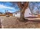 View of the backyard with mature tree and a lawn mower next to a white home at 801 S Leyden St, Denver, CO 80224