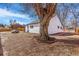 Backyard view featuring a mature tree, lawn mower, and side of the house at 801 S Leyden St, Denver, CO 80224