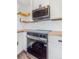 Stylish kitchen equipped with modern appliances, including a sleek range, complemented by floating shelves and a unique wine rack at 801 S Leyden St, Denver, CO 80224