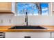 Farmhouse kitchen sink paired with butcher block counters and a modern faucet under a window at 801 S Leyden St, Denver, CO 80224