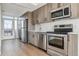 Modern kitchen with stainless steel appliances and wood cabinets at 3575 Chestnut Pl # 406, Denver, CO 80216