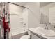 Clean bathroom with a white sink, toilet, and tub-shower combo featuring a decorative shower curtain at 1353 Reynolds St # 2B, Fort Lupton, CO 80621