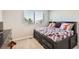 Comfortable bedroom featuring a black bed frame with built-in storage and a bright window at 1353 Reynolds St # 2B, Fort Lupton, CO 80621