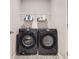 Well-equipped laundry room with modern black washer and dryer and overhead shelving at 1353 Reynolds St # 2B, Fort Lupton, CO 80621