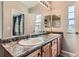 Bathroom with a double sink, a large mirror, wooden cabinets, and plenty of natural light at 9424 Ridgeline Blvd # I, Highlands Ranch, CO 80129