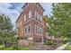 Charming townhome features brick facade, landscaped front yard, and inviting entry steps with iron railings at 9424 Ridgeline Blvd # I, Highlands Ranch, CO 80129