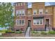 Charming townhome features brick facade, landscaped front yard, and inviting entry steps with iron railings at 9424 Ridgeline Blvd # I, Highlands Ranch, CO 80129