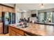 Open concept kitchen with an island that has a stainless steel sink, hardwood cabinets, and modern appliances at 9424 Ridgeline Blvd # I, Highlands Ranch, CO 80129