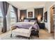 Main bedroom featuring a bench, sitting area, gray walls, a queen-size bed, and large windows at 9424 Ridgeline Blvd # I, Highlands Ranch, CO 80129