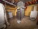 Unfinished basement with yellow walls, laundry appliances, and the home's furnace at 1501 E Caley Ave, Centennial, CO 80121