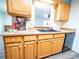 Kitchen counter with wood cabinets, black double sink, and gray dishwasher at 1501 E Caley Ave, Centennial, CO 80121