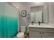 Bathroom featuring a shower with a teal curtain, toilet, and a gray vanity at 17761 E 95Th Pl, Commerce City, CO 80022