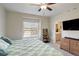 Bedroom featuring a ceiling fan and window with an attached bathroom at 17761 E 95Th Pl, Commerce City, CO 80022