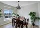 Bright dining area with a modern chandelier, wooden table set, and plenty of natural light at 17761 E 95Th Pl, Commerce City, CO 80022