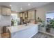 Modern kitchen with light-colored cabinets, stainless steel appliances, tile backsplash, and breakfast bar at 17761 E 95Th Pl, Commerce City, CO 80022