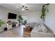 Relaxing living area featuring wood flooring, large windows, and modern entertainment center at 17761 E 95Th Pl, Commerce City, CO 80022