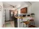 Efficient kitchen featuring wood cabinets, stainless steel appliances, bar seating, and a convenient washer/dryer area at 2028 Perry St, Denver, CO 80212