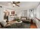 Inviting living room features a ceiling fan, hardwood floors, stylish furniture, and seamless flow to the kitchen at 2028 Perry St, Denver, CO 80212