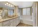 Elegant bathroom with granite countertops, double sinks, and a soaking tub at 6397 Deframe Way, Arvada, CO 80004