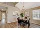 Dining area with hardwood floors and view into kitchen at 6397 Deframe Way, Arvada, CO 80004