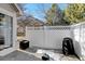 Small patio with a grill, storage bin, and a white fence at 6397 Deframe Way, Arvada, CO 80004