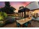 Landscaped backyard with a dining table, modern home exterior, and vibrant flowers in bloom at 200 Magnolia St, Denver, CO 80220