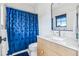 Bathroom with vibrant blue shower curtain, modern vanity, and stylish mirror at 200 Magnolia St, Denver, CO 80220