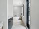 Bright bathroom with a soaking tub, black framed glass door, and stone tile flooring at 200 Magnolia St, Denver, CO 80220