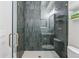 Modern bathroom featuring grey tiled walls, a glass door shower, and hexagon tile flooring at 200 Magnolia St, Denver, CO 80220