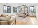 Bright bedroom features a four-poster bed, sitting area and large windows at 200 Magnolia St, Denver, CO 80220
