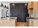 The kitchen features black and wood cabinets, marble countertops, an island sink, and a gourmet oven range at 200 Magnolia St, Denver, CO 80220