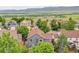 Aerial view of the property and neighborhood, showcasing a well-maintained home with a green, lush landscape at 8838 S Dudley St, Littleton, CO 80128