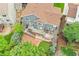 Aerial view of the home's backyard with a spacious deck, stone patio, and lush landscaping at 8838 S Dudley St, Littleton, CO 80128