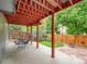 View of the concrete back patio with a table and chairs underneath a covered area with view to the fenced yard at 8838 S Dudley St, Littleton, CO 80128
