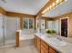 This warm bathroom features double sinks, a walk-in shower, and a soaking tub with natural light at 8838 S Dudley St, Littleton, CO 80128