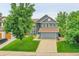 Charming two-story home featuring a well-manicured lawn, mature trees, and a spacious two-car garage at 8838 S Dudley St, Littleton, CO 80128