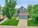 Charming two-story home with mature trees, well-manicured lawn, and attached two car garage at 8838 S Dudley St, Littleton, CO 80128