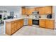 A functional kitchen with tile counters, stainless steel appliances, and wooden cabinets at 8838 S Dudley St, Littleton, CO 80128
