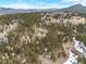 Panoramic aerial view showing multiple luxury mountain homes surrounded by a lush forest landscape at 12653 Rancho Ct, Conifer, CO 80433
