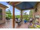 Inviting covered deck with comfortable seating, a cozy fireplace, and stunning views of the surrounding landscape at 12653 Rancho Ct, Conifer, CO 80433