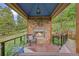 Outdoor living space with stone fireplace, seating, and views of nature at 12653 Rancho Ct, Conifer, CO 80433