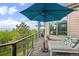 Relaxing deck area with an umbrella, lounge chair, and scenic views of the wooded landscape and distant mountains at 12653 Rancho Ct, Conifer, CO 80433