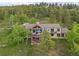 Stunning aerial view of a house with multi-level decks, surrounded by lush greenery and mature trees on a hillside at 12653 Rancho Ct, Conifer, CO 80433