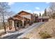 Side view of a house with a garage and stone porch, showcasing the home's architecture and design at 12653 Rancho Ct, Conifer, CO 80433