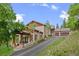 Inviting home exterior with a paved driveway, mature landscaping and stone accents at 12653 Rancho Ct, Conifer, CO 80433