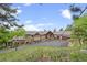 Well-maintained home exterior featuring a driveway, mature trees and attractive landscaping at 12653 Rancho Ct, Conifer, CO 80433