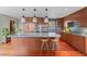 Spacious kitchen featuring custom wood cabinets, stainless appliances, and an island with seating at 12653 Rancho Ct, Conifer, CO 80433