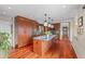 A stylish kitchen featuring wood cabinets, an island with barstool seating, and modern pendant lighting at 12653 Rancho Ct, Conifer, CO 80433