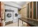 Bright laundry room with washer, dryer, cabinets, folding table, and decorative wall hanging at 12653 Rancho Ct, Conifer, CO 80433